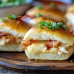golden Crack Chicken Sliders with melted cheese, crispy bacon, and ranch-seasoned chicken on soft Hawaiian rolls, served on a rustic platter.